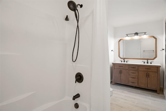 bathroom with a sink, toilet,  shower combination, and double vanity