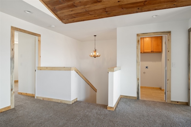 spare room with recessed lighting, baseboards, light colored carpet, and an inviting chandelier