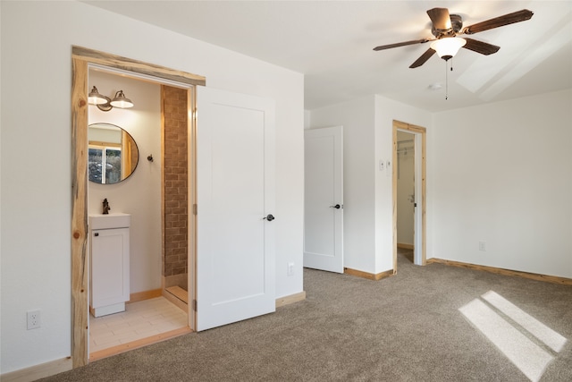 unfurnished bedroom featuring a sink, connected bathroom, baseboards, and carpet floors