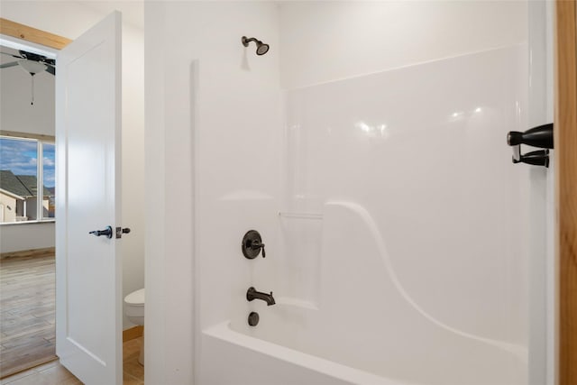 full bath with toilet, shower / bathtub combination, and ceiling fan