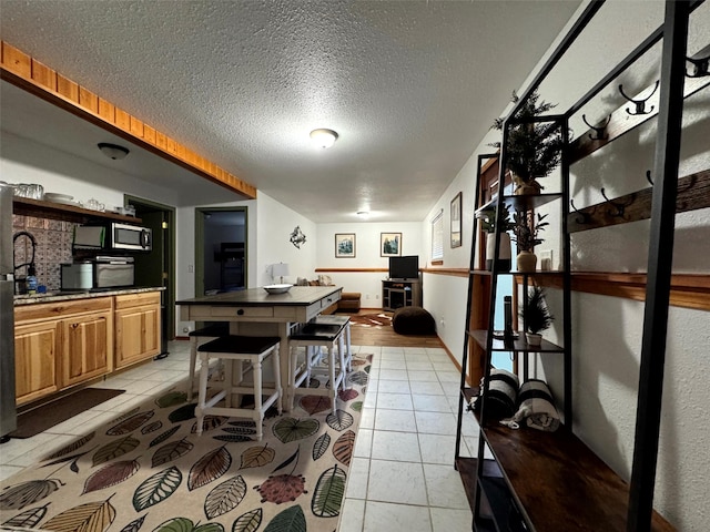 dining area with light tile patterned floors and a textured ceiling