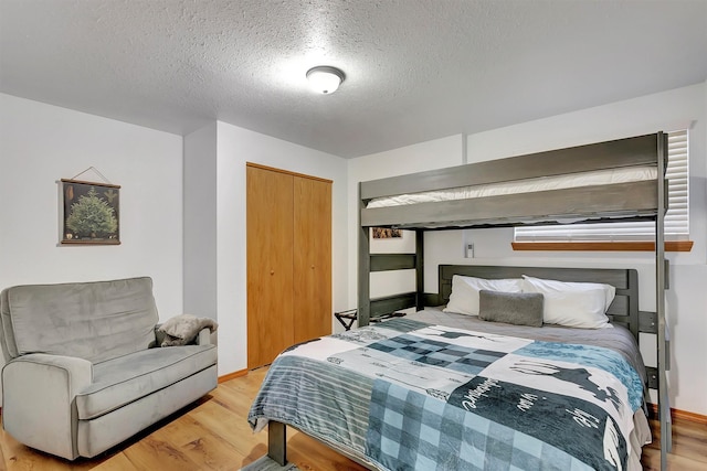 1081 Old Barn Rd, Seeley Lake, MT 59868 - bedroom with a textured ceiling, light wood finished floors, and a closet