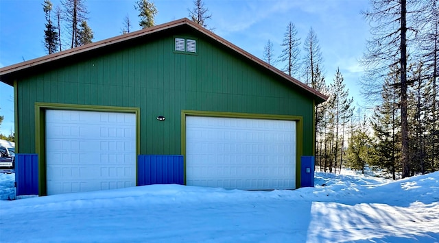 snow covered garage with a garage