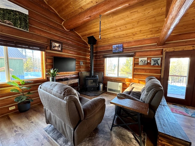 living area featuring beamed ceiling, high vaulted ceiling, hardwood / wood-style floors, wooden ceiling, and a wood stove