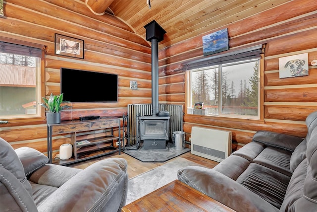 1081 Old Barn Rd, Seeley Lake, MT 59868 - living room with rustic walls, a wood stove, lofted ceiling, wood finished floors, and wooden ceiling