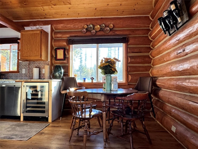 dining room with wine cooler, rustic walls, and light wood-style floors