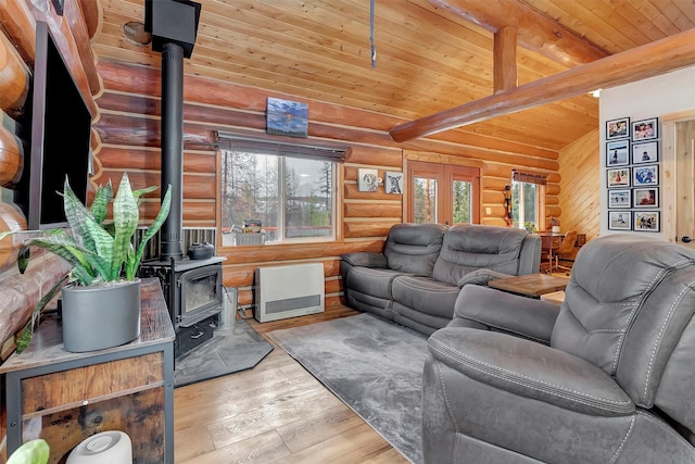 1081 Old Barn Rd, Seeley Lake, MT 59868 - living area featuring log walls, a wood ceiling with exposed beams, a wood stove, and hardwood / wood-style floors