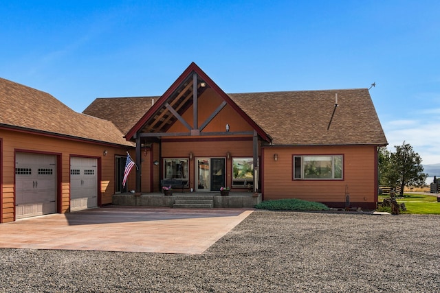 view of front of property with a garage and a shingled roof