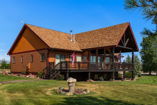 back of house featuring a wooden deck, a yard, and roof with shingles