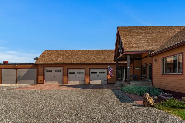 view of front facade featuring a shingled roof and a garage