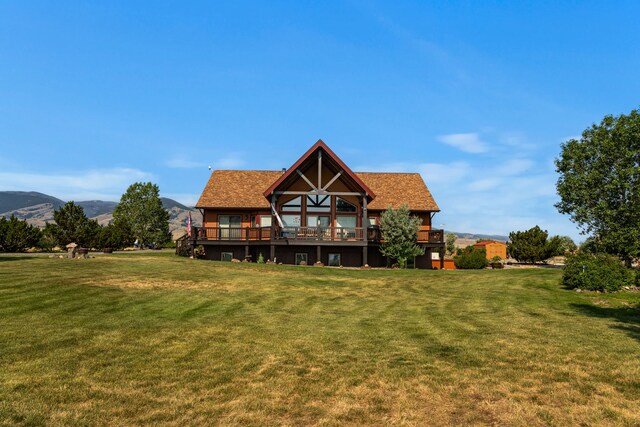 back of house featuring a deck with mountain view and a lawn