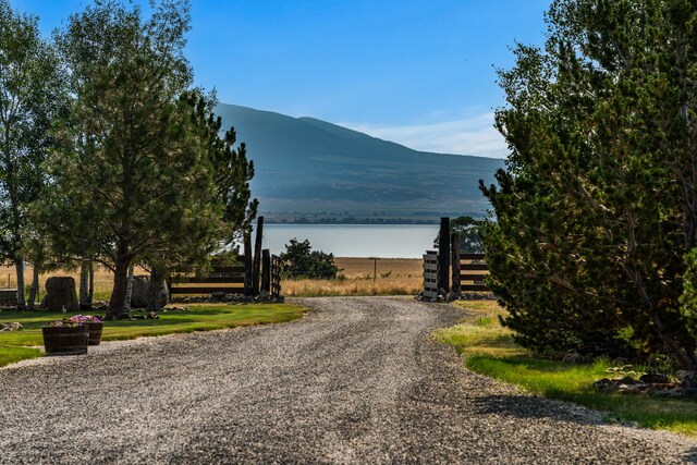 view of road featuring a water and mountain view and driveway
