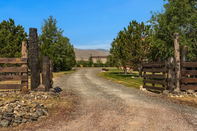 view of road featuring a mountain view and gravel driveway