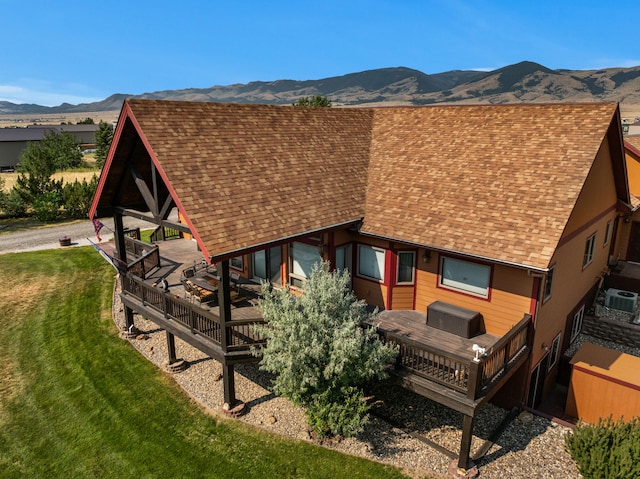 back of property featuring a gazebo, a yard, a deck with mountain view, and a shingled roof