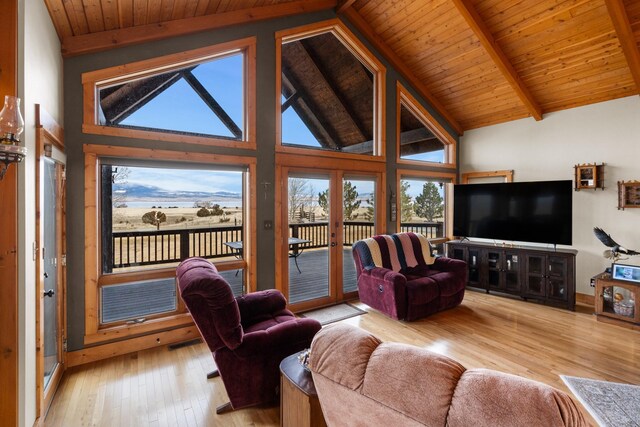 living area featuring high vaulted ceiling, beam ceiling, wood ceiling, light wood-style floors, and french doors