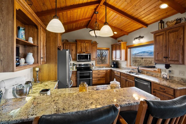 kitchen featuring brown cabinets, a sink, stainless steel appliances, a peninsula, and light stone countertops