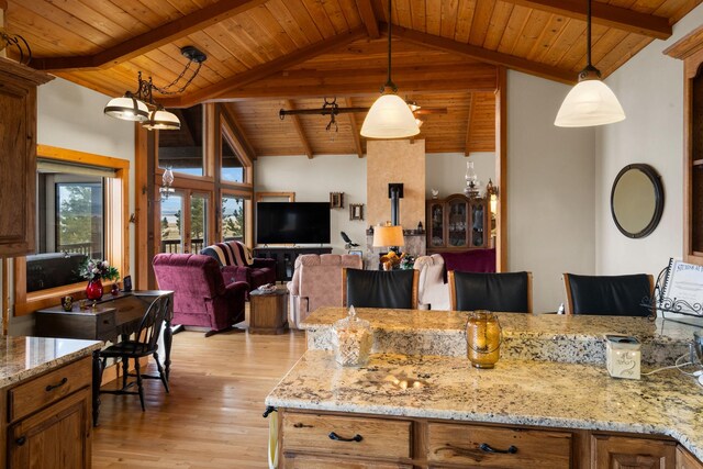 kitchen featuring hanging light fixtures, wooden ceiling, light wood finished floors, and beam ceiling