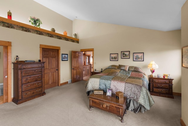 carpeted bedroom featuring baseboards and high vaulted ceiling