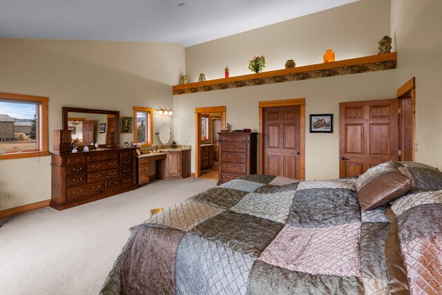 bedroom featuring connected bathroom, baseboards, light colored carpet, and high vaulted ceiling