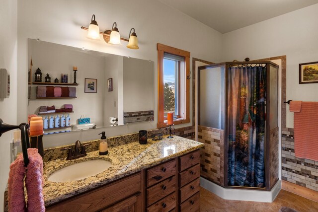 full bath with vanity, tile walls, a stall shower, and tile patterned floors