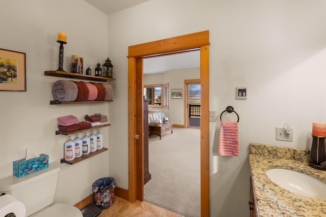 bathroom featuring vanity, toilet, and baseboards