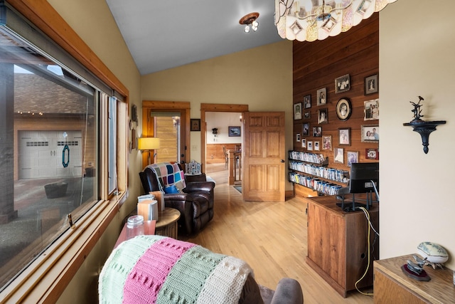 living area featuring wood walls, light wood-type flooring, and vaulted ceiling