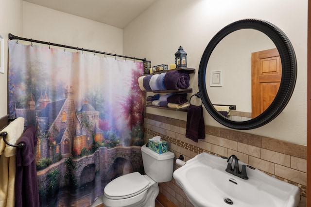 full bath featuring toilet, tile walls, a shower with shower curtain, and a sink