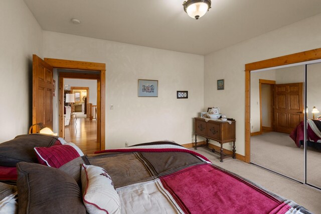 carpeted bedroom with a closet and baseboards