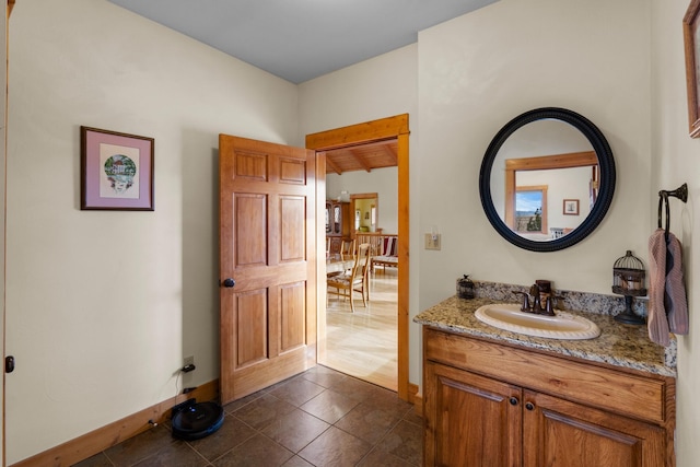 bathroom with tile patterned floors, baseboards, and vanity
