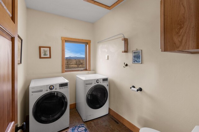 clothes washing area with visible vents, baseboards, laundry area, and washer and clothes dryer