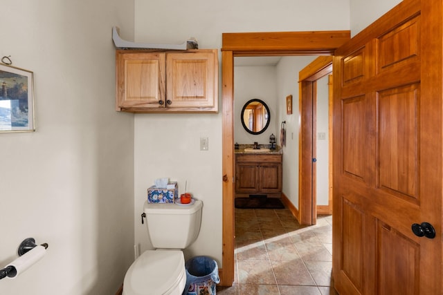 half bath featuring toilet, vanity, and baseboards