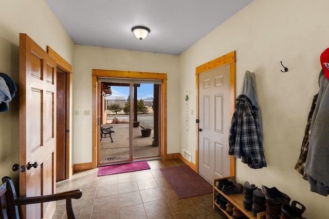 tiled entrance foyer with visible vents and baseboards