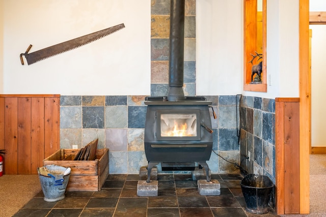 interior details with a fire extinguisher, wainscoting, and a wood stove