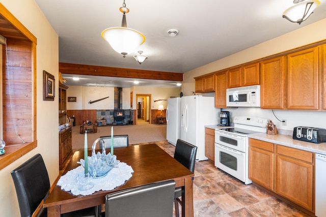 kitchen with white appliances, brown cabinetry, light countertops, decorative light fixtures, and open floor plan