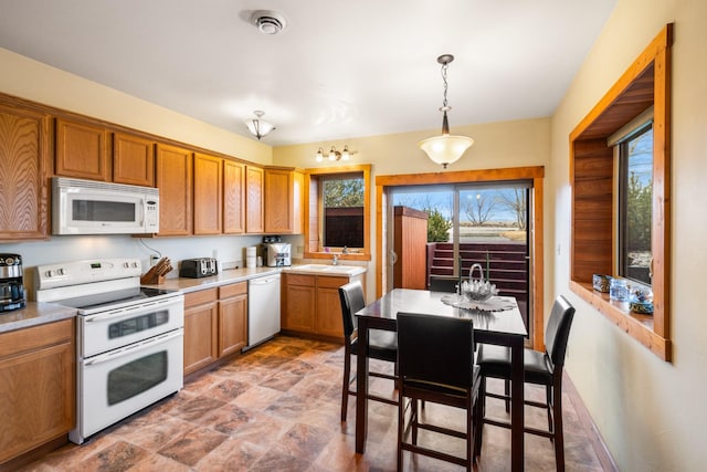 kitchen with visible vents, white appliances, light countertops, baseboards, and hanging light fixtures