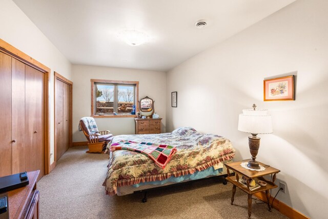 carpeted bedroom with baseboards and multiple closets