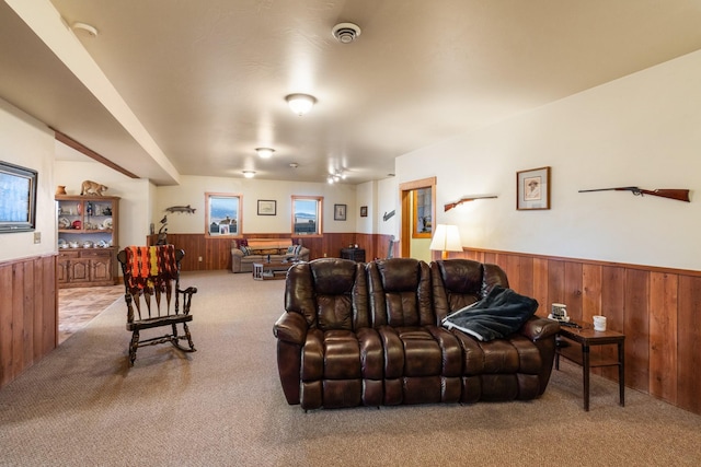 carpeted living room featuring wooden walls and wainscoting