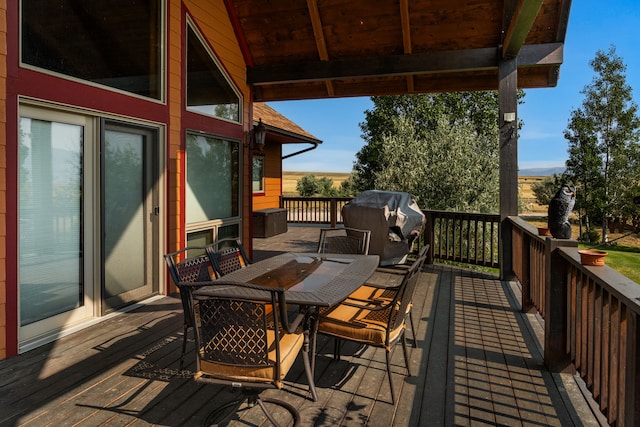 wooden deck with outdoor dining area and grilling area