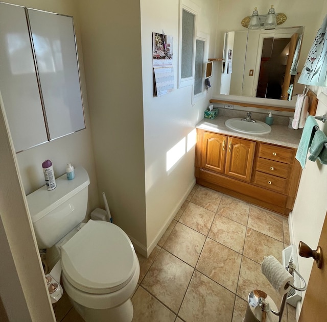 bathroom featuring tile patterned flooring, toilet, vanity, and baseboards