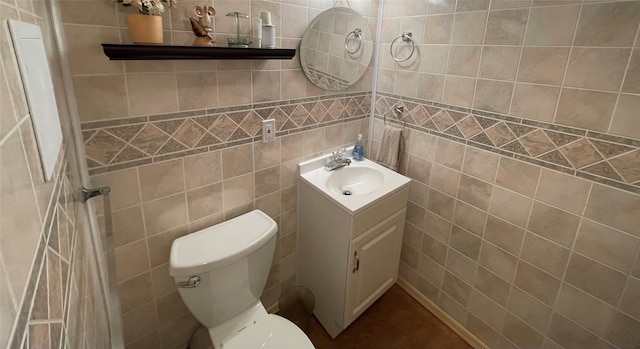 half bath with toilet, tile walls, and vanity