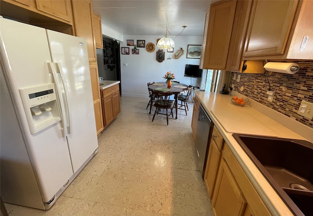 kitchen featuring a sink, white refrigerator with ice dispenser, light countertops, and stainless steel dishwasher