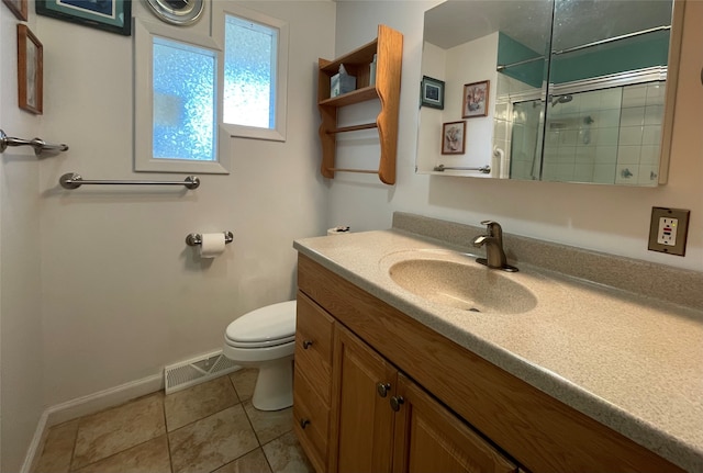 bathroom with visible vents, toilet, tile patterned flooring, tiled shower, and vanity