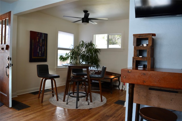 dining room with visible vents, baseboards, wood finished floors, and a ceiling fan