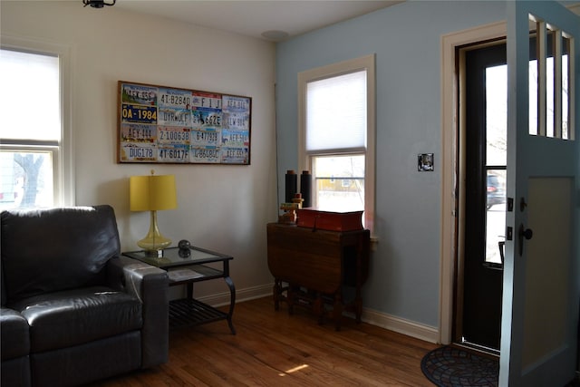 living area with baseboards and wood finished floors