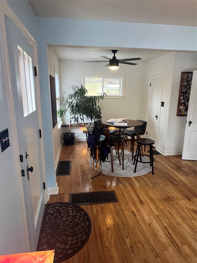 dining area featuring visible vents, baseboards, wood finished floors, and a ceiling fan