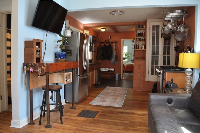 kitchen featuring wood finished floors, baseboards, visible vents, open shelves, and stainless steel appliances