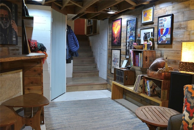 staircase featuring wooden walls