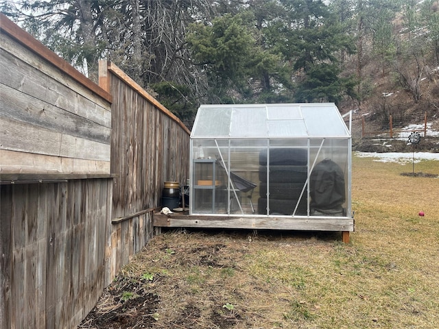 view of greenhouse with a yard