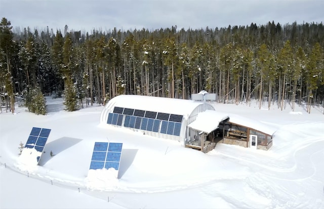 snowy aerial view featuring a wooded view