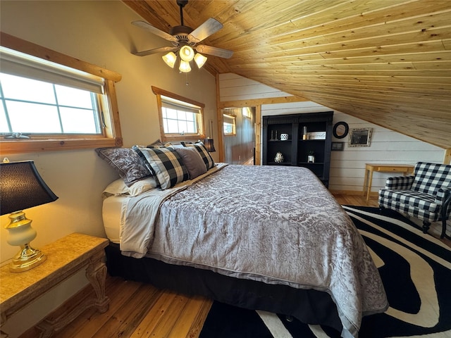 bedroom featuring ceiling fan, wood walls, lofted ceiling, wooden ceiling, and wood finished floors